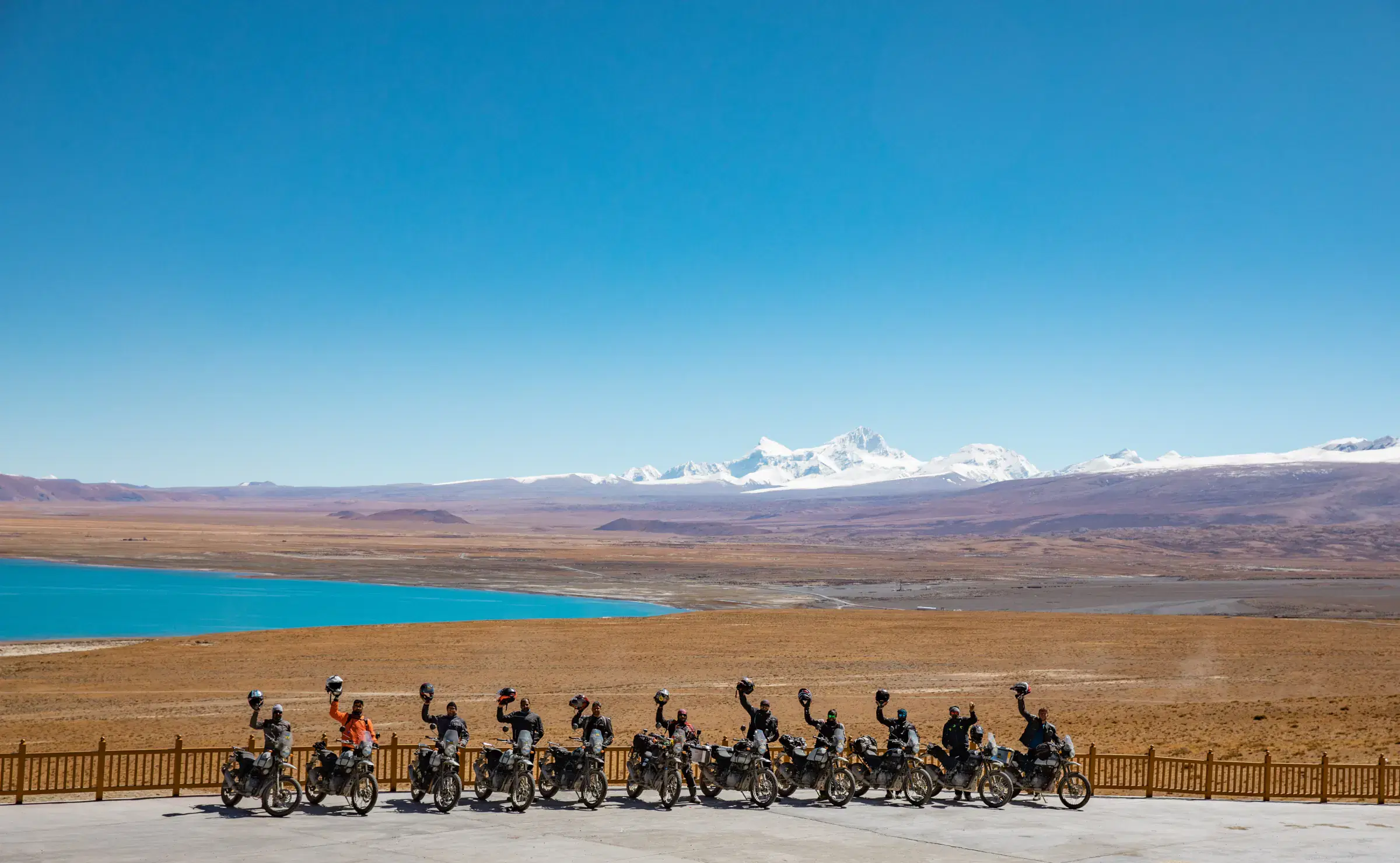 Outdoor vehicle scene featuring a vehicle, rocky terrain, a built structure, and blue sky.